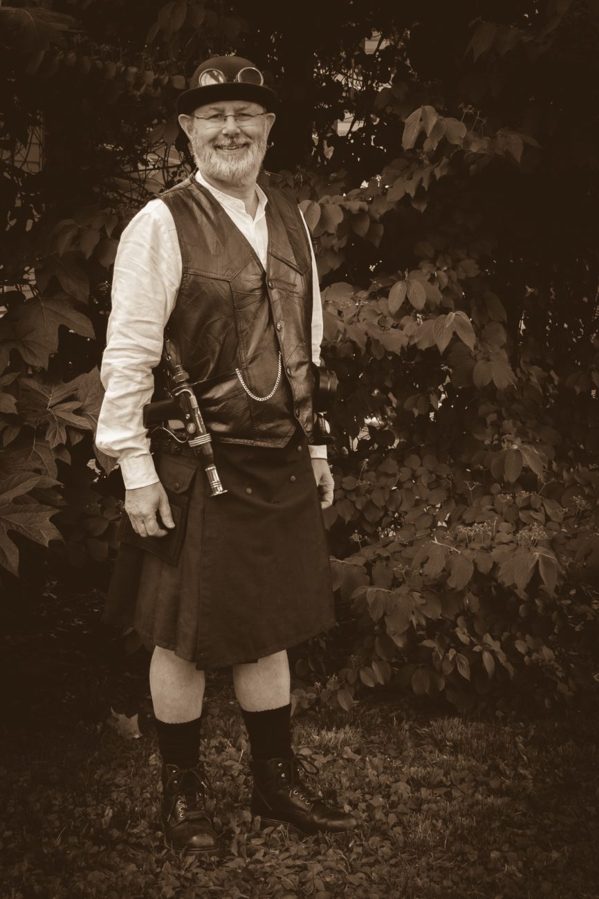 Photograph of Gary Allman wearing a Steam Punk outfit featuring a kilt and leather vest